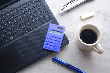 コーヒーを飲みながらノートパソコン（黒）で仕事をする