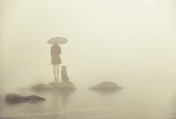 Girl with umbrella and dog on a little island in the middle of the water in the fog