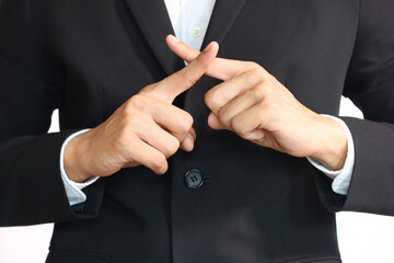 Asian businessman in black suit cross fingers to say no, an x, rejected, not accepted, and not...