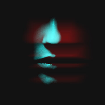 Abstract Fashion Concept. Woman Face In Black Shadow Background With Copy Space In Red And Blue Color Split Effect Style. Nose Is In Camera Focus. Selective Focus And Image With Shallow Depth Of Field