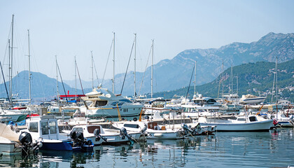 Fototapeta na wymiar Yachts port in Montenegro in adriatic sea. Boats pier in sunny day with beautiful Mediterranean nature