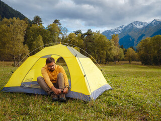 trip to Caucasus mountains, Arkhyz, Teberdinsky reserve. Man traveler relaxing in mountains in tent camping outdoor Travel adventure lifestyle concept hiking active vacations.