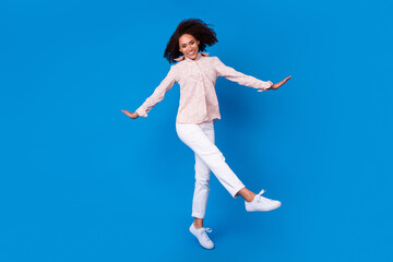 Full length portrait of active energetic cheerful girl jump have good mood isolated on blue color...