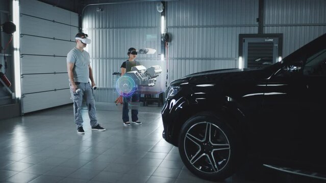 Two technicians check a car engine using virtual reality technology in a workshop. Experts discuss the characteristics of the motor of the car, its components and parts