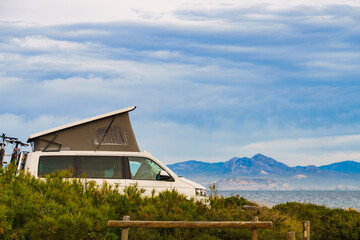 Van camper with tent on roof top camp on nature © anetlanda
