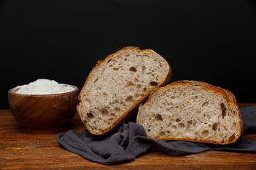 Sliced homemade wheat-rye bread on a linen towel on a wooden table	