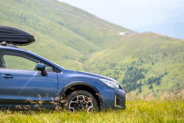 Blue off road car on mountain trail. Traveling by auto, adventure in wildlife, expedition or extreme travel on SUV automobile