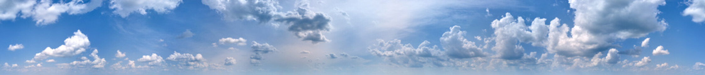Bright panoramic landscape of white puffy cumulus clouds on blue clear sky