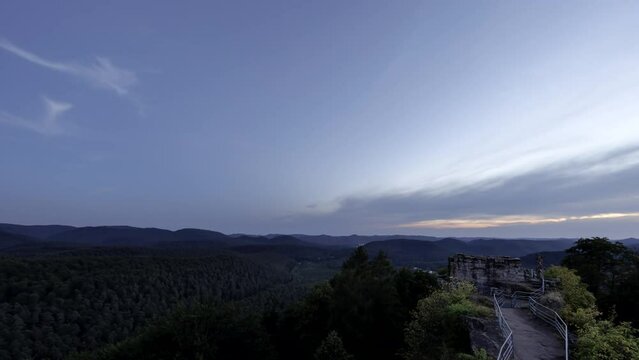 Time lapse shot at colorful dusk of ruin of Falkenstein with mountain range of Vosges. Milky Way appears when it gets dark.