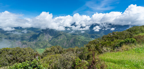 Fototapeta na wymiar Panorama of mountain peaks and fresh vegetation on top of the hill in Reunion island