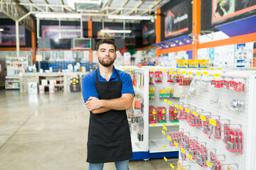 Portrait of a young man and hardware store worker looking at the camera