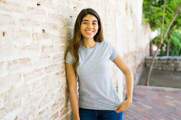 Cheerful latin woman with a gray mockup blank t shirt