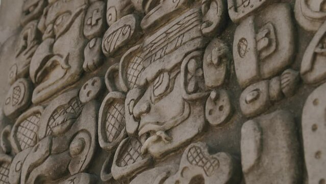 Footage that is close to of an ancient Mayan artifact with symbols carved into the front of it.