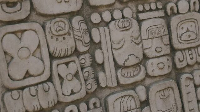 Footage that is rotating of an ancient Mayan artifact with symbols carved into the front of it.