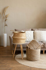 Various wicker baskets for interior decoration stand on the floor in a modern living room.