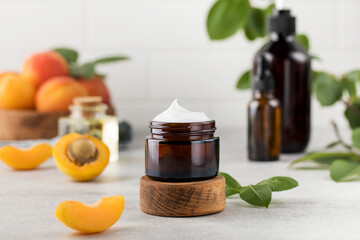 Mockup of an open glass brown jar of moisturizing face cream with apricot kernel extract. Natural...
