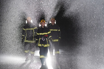 Portrait of a group of firefighters standing and walking brave and optimistic with a female as team leader.