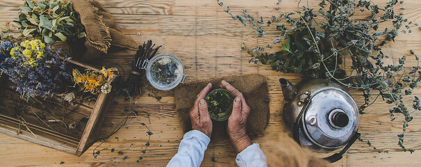 Grandmother makes tea with medicinal herbs. Selective focus. - obrazy, fototapety, plakaty