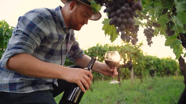 Authentic shot of happy successful male winemaker is tasting a flavor and checking red wine quality 