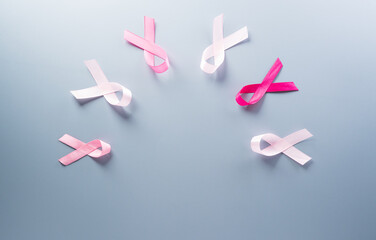 Pink ribbon on pastel paper background for supporting breast cancer awareness month campaign.