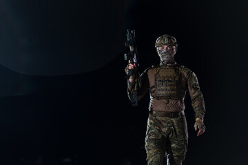 Army soldier in Combat Uniforms with an assault rifle, plate carrier and combat helmet going on a...