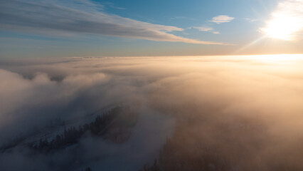 Sunrise breaking through the thick white fog at the top of Vuokatti Hill, a ski resort in Vuokatti,...