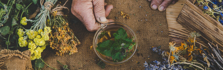 Grandmother makes tea with medicinal herbs. Selective focus.