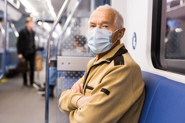 Portrait of mature man in personal protective equipment in subway carriage