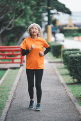 white-haired elderly person exercising in the park early in the morning.