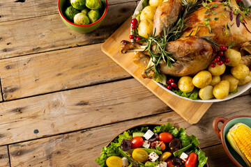 Obraz premium Overhead view of thanksgiving table roast turkey, vegetables and copy space on wood