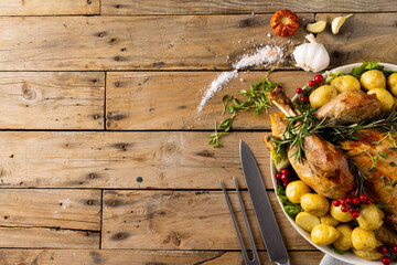 Obraz premium Overhead view of thanksgiving table with roast turkey, potatoes and copy space on wood