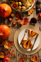 Naklejka premium Overhead view of thanksgiving roast turkey with potatoes and autumn decoration on wood