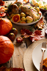 Naklejka premium Overhead view of thanksgiving roast turkey with potatoes and autumn decoration on wood