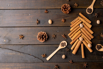 Image of christmas decoration with spices forming christmas tree and copy space on wooden background