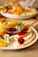 Obraz premium Close up of plate of thanksgiving roast turkey with vegetables on wooden background