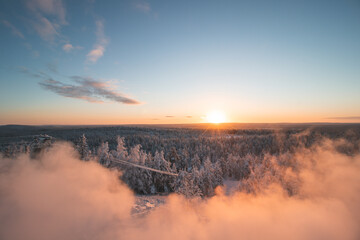 Obraz na płótnie Canvas Breathtakingly frosty morning at a viewpoint in Rovaniemi, a Finnish city on the Arctic Circle. A view of the snowy landscape at golden hour. Snow-covered untouched forest