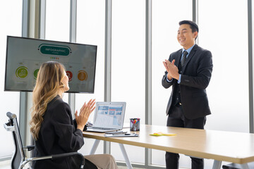 Cheerful young Asian businessman Excited and glad applauded. About successful startup projects Happy Asian colleagues celebrating business success in office meeting.