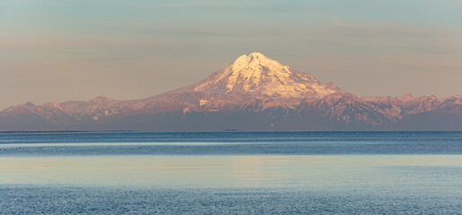 Panorama image of the glacier capped volcano Mount Redoubt from Kenai peninsula, Alaska in early morning light