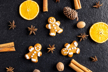Fototapeta na wymiar Image of gingerbread man cinnamon sticks and christmas decoration on black