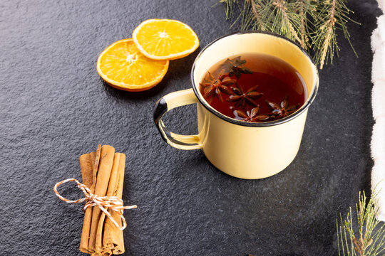 Image of mug of christmas tea with spices and lemon and christmas decorations