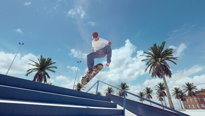 Skateboarder doing a trick in a skate park - obrazy, fototapety, plakaty