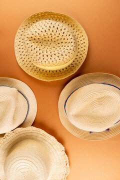 Vertical image of straw hats on yellow surface