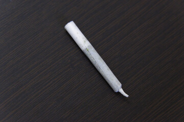Marijuana or Cannabis Joints. Close-up of a rolled hashish joint (cigarette with hash or marijuana) on a black table background. Weed and Ganja-joint cigarette.close-up