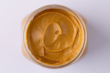 Image of jar with peanut butter on white surface