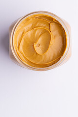 Image of jar with peanut butter on white surface