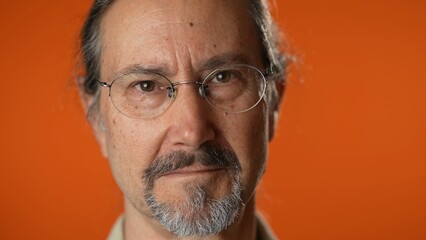 Closeup portrait of smiling happy mature man on isolated on solid orange background.