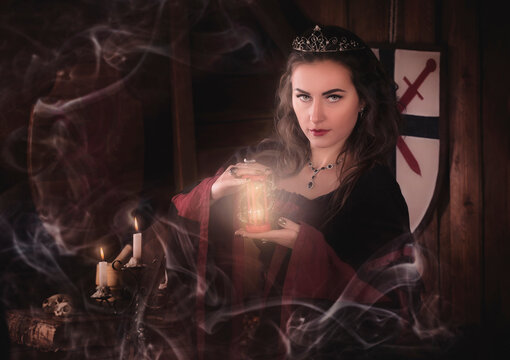 Fantastic medieval woman with an hourglass in her hands. Magic hourglass, time of mysticism. Smoke Mysticism, witch, deceit, magic. Royal velvet vintage red dress with gold, witch, enchantress, queen,