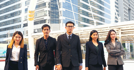 Fototapeta premium Portrait Group of businesspeople arms crossed smiling look at camera in modern city background. Happy Businessman, businesswoman teams partnership. Business people teams positive teamwork standing.