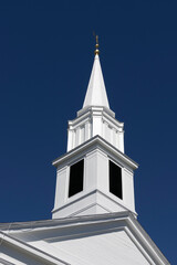 Fototapeta na wymiar white church steeple against dark blue sky