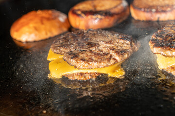 Make burgers on the grill restaurant. Burgers cooking on a gas grill, how to make a burger step by step. A person using a spatula to cut meat. a person cutting meat on a grill with a knife